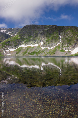 Beautiful reflection of a mountain on Rila mountain in the Kidney lake, one of seven Rila lakes, distant Lakes peak, transparent, clear water and underwater stones photo