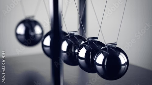 The chrome balls of a Newton’s Cradle colliding in slow motion