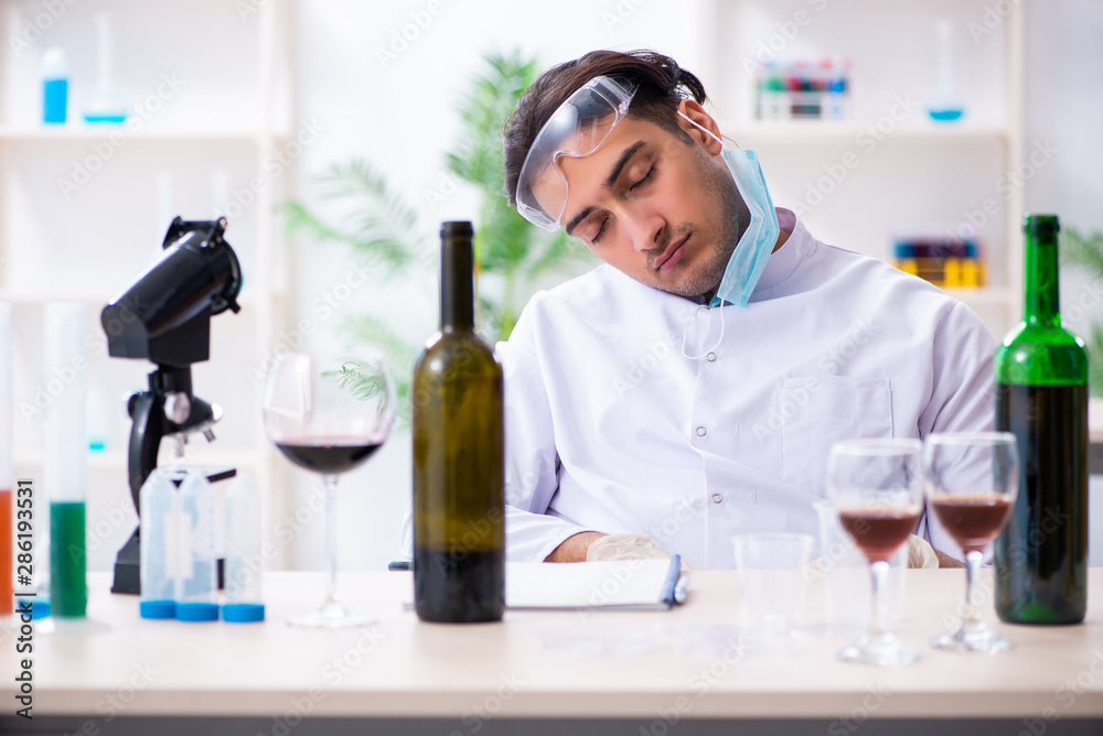Male chemist examining wine samples at lab Male chemist examining wine samples at lab