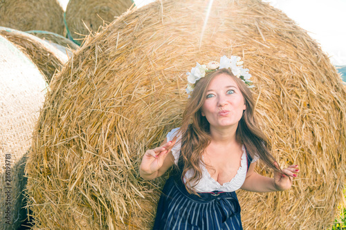 Frau in Tracht vor einem Strohballen an einem sonnigem Tag in bayern photo