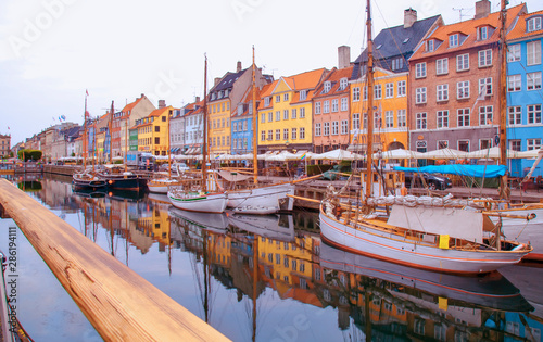 Summer morning view of Nyhavn pier with color buildings, ships, yachts and other boats in the old part of town of Copenhagen, Denmark. Editorial image.