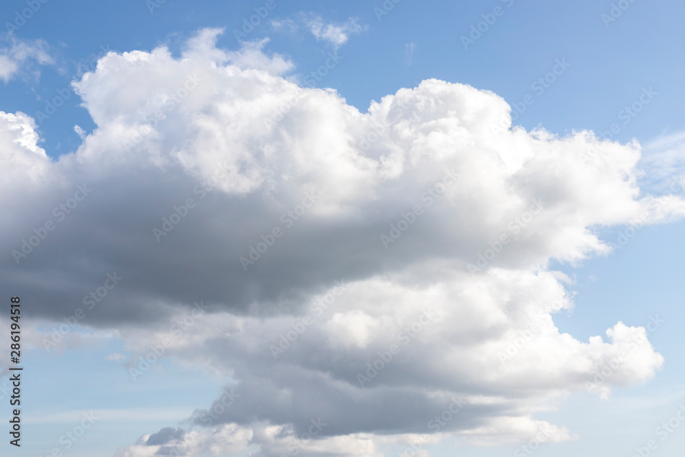 Blue sky with white clouds. Big dark cloud on the blue sky. Cloudy daytime weather. Background with free space and empty place. Blue sky with white clouds. Big dark cloud on the blue sky. Cloudy daytime weather. Background with free space and empty place.