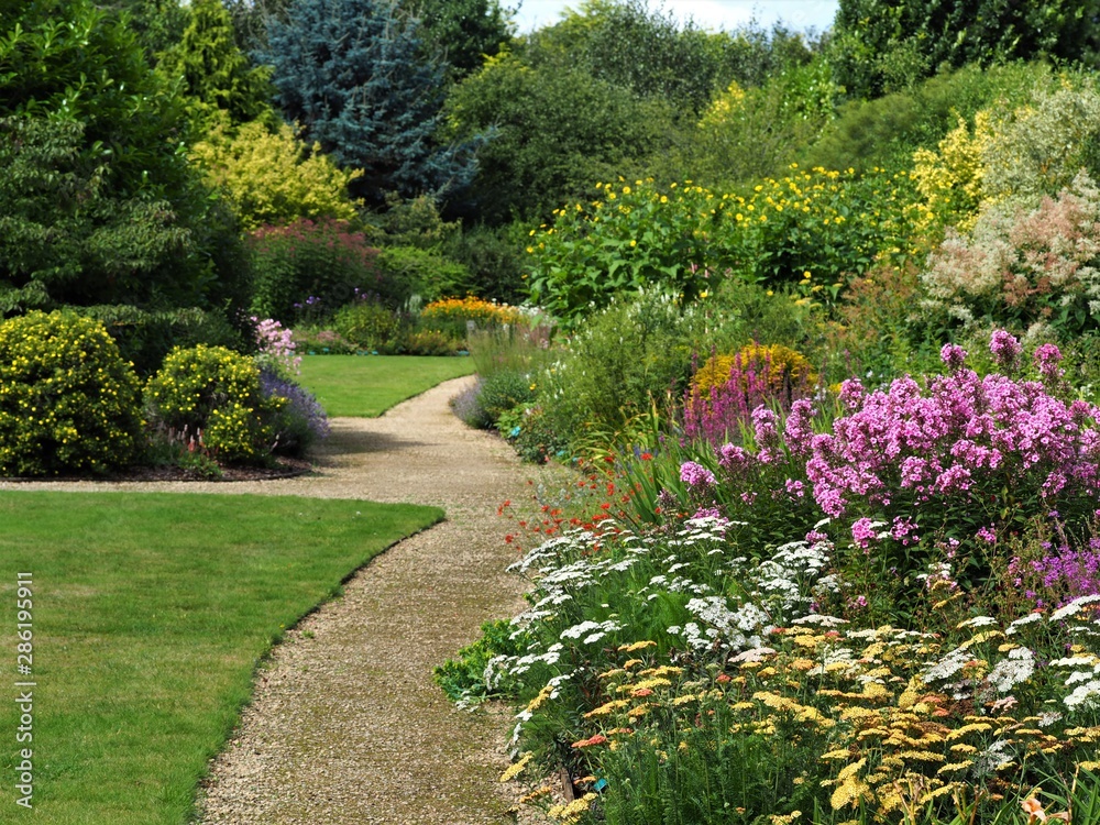 English garden with a grass lawns, summer flower borders, and