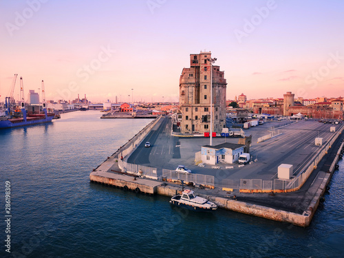 View of a quay of the port of Livorno at sunset. Old abandoned building. Industrial archeology.