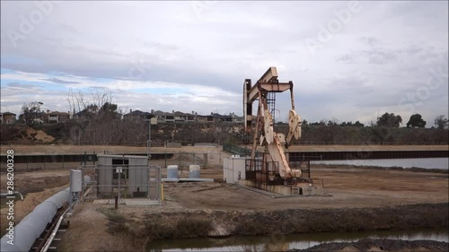 Oil derricks pumping with cloudy sky