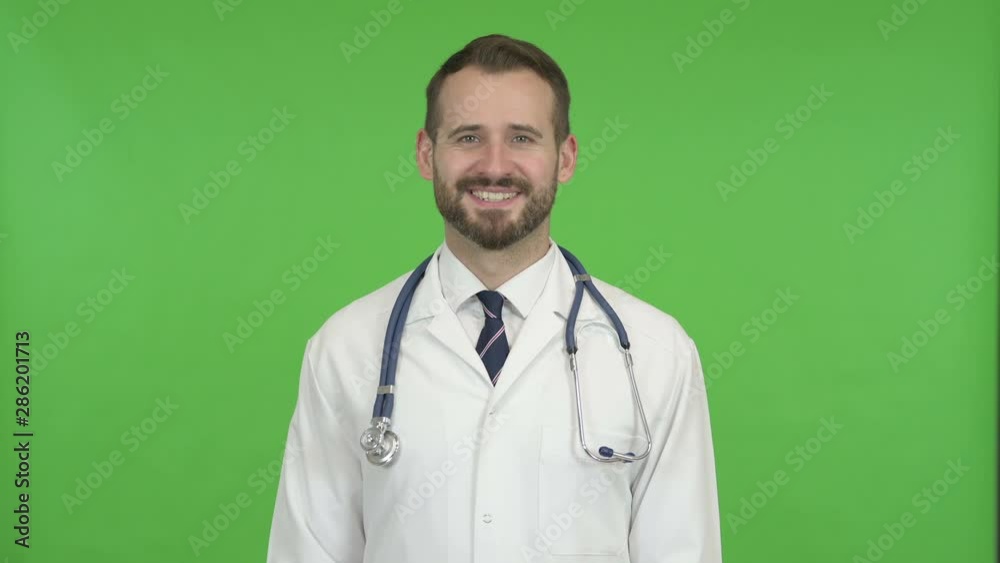 Cheerful Doctor Smiling at Camera against Chroma Key Cheerful Doctor Smiling at Camera against Chroma Key