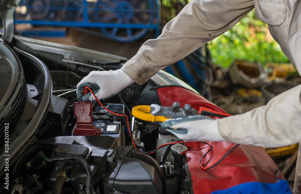 Fototapeta premium Auto repair service technician checking car battery
