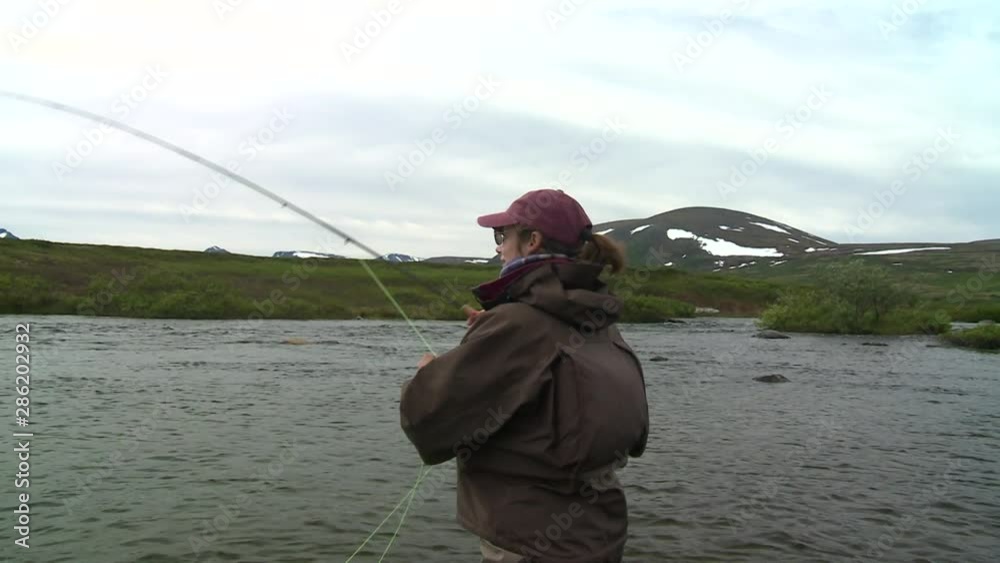 Float plane flys by in distance, angler in foreground