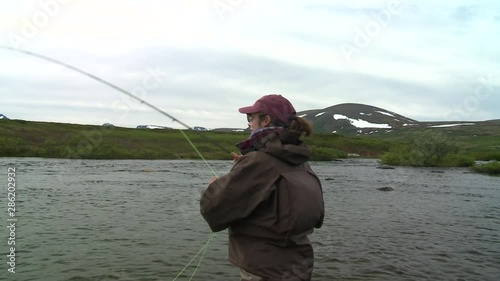 Float plane flys by in distance, angler in foreground photo