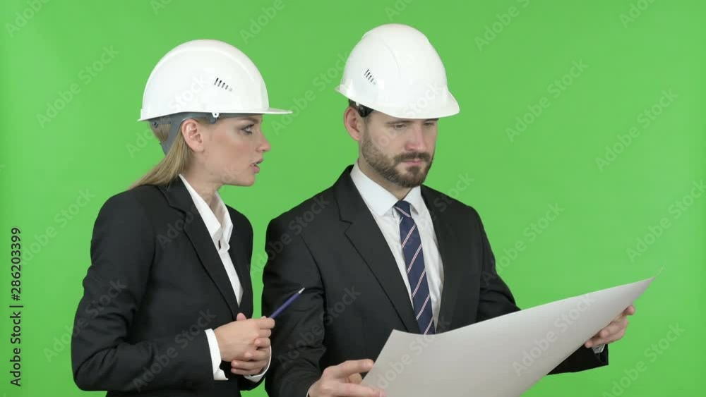 Engineers Studying Construction Blueprint Against Chroma Key Engineers Studying Construction Blueprint Against Chroma Key