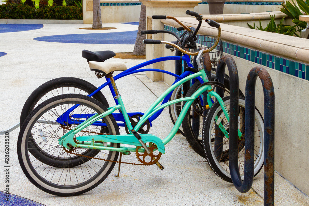 Rusty beach cruiser bicycles locked up on bike rack. Rusty beach cruiser bicycles locked up on bike rack.