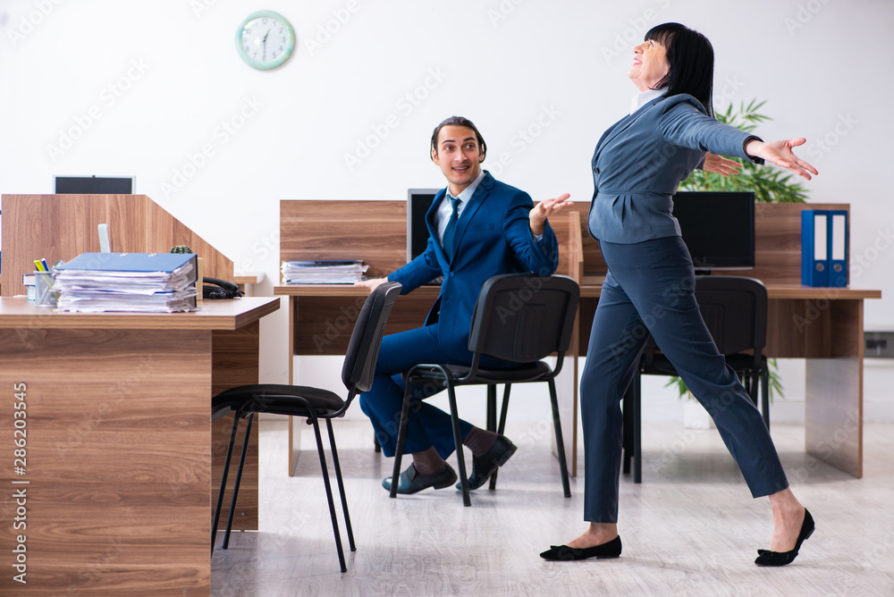 Two employees doing sport exercises in the office Two employees doing sport exercises in the office