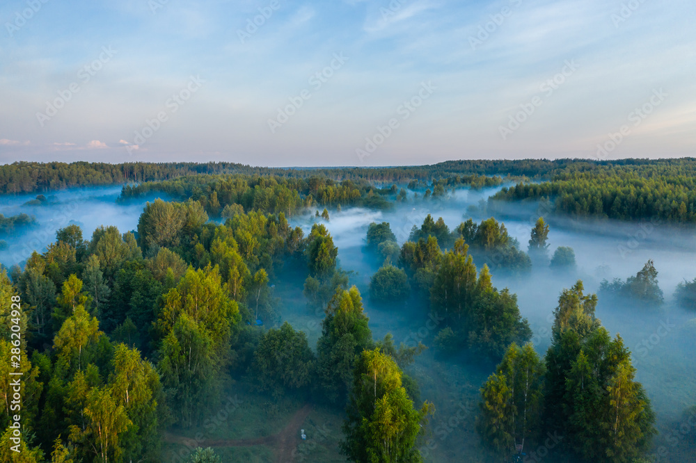 Aerial view of the forest, field and river covered with layers of thick morning fog Aerial view of the forest, field and river covered with layers of thick morning fog
