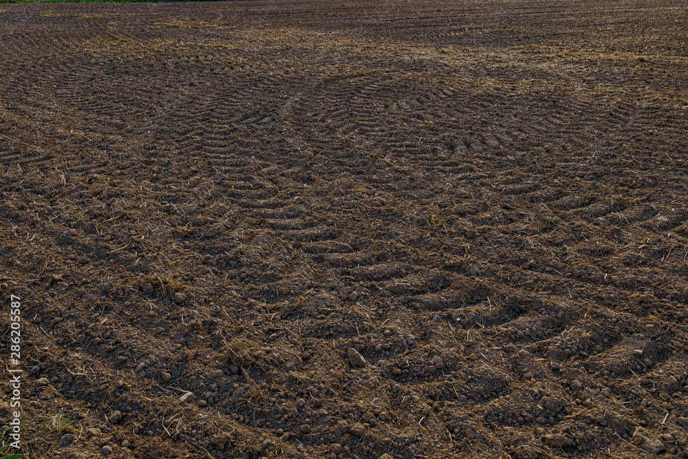 Close up top view of tire pattern from heavy tractor wheel mark trail on agricultural soil. Close up top view of tire pattern from heavy tractor wheel mark trail on agricultural soil.