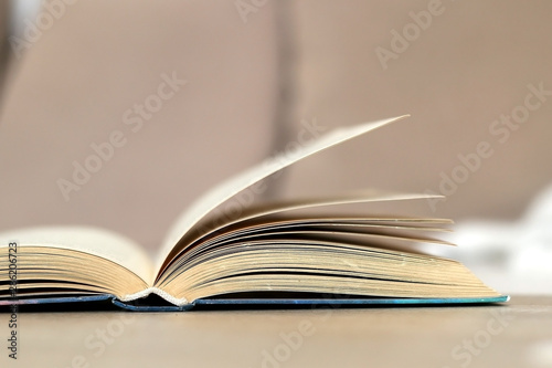 Open book on a living room table. Selective focus.