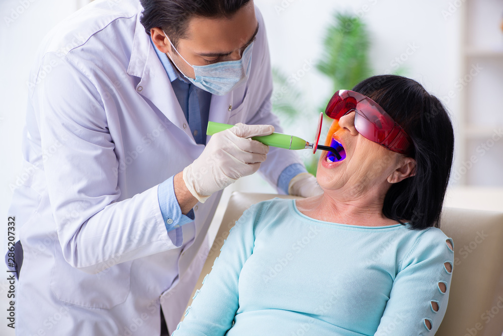 Naklejka premium Old woman visiting young doctor dentist