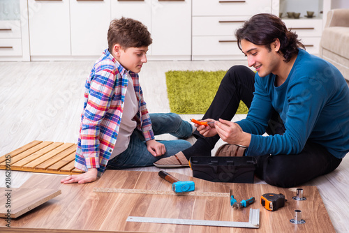 Young carpenter teaching his son