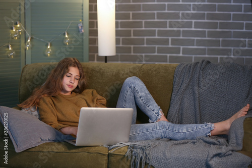 Teenage girl with laptop on...