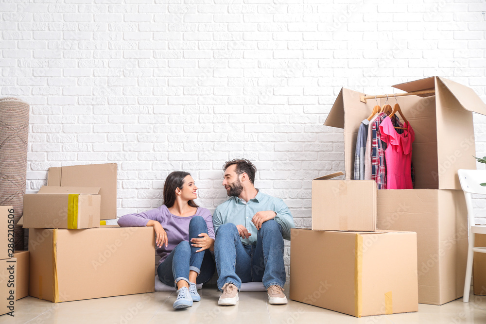Young couple with belongings after moving into new house Young couple with belongings after moving into new house