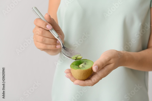 Woman eating fresh kiwi, closeup