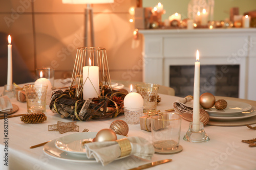 Beautiful table setting with Christmas decorations in living room photo