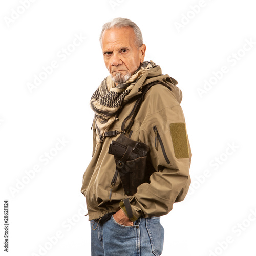 Side shot of a mature doomsday prepper with a gun and shemagh. 