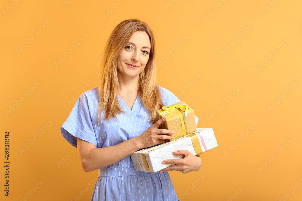 Beautiful woman with gifts on color background Beautiful woman with gifts on color background