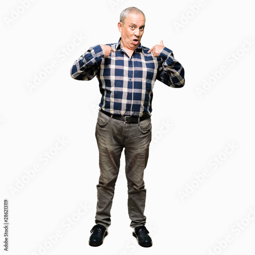 Handsome senior man wearing casual shirt looking confident with smile on face, pointing oneself with fingers proud and happy.