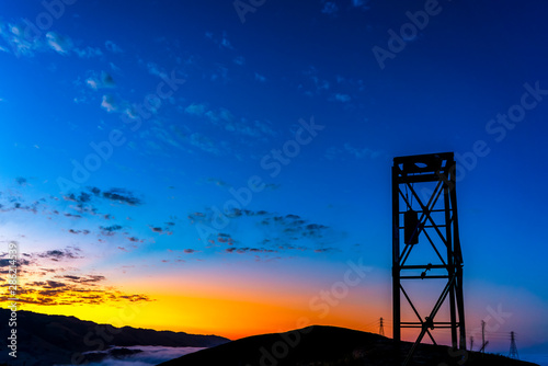 Silhouetted Tower on Hill at Sunrise or Sunset
