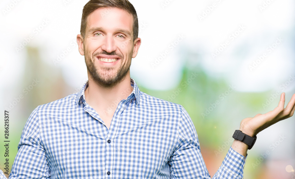 Handsome business man with blue eyes Smiling showing both hands open palms, presenting and advertising comparison and balance Handsome business man with blue eyes Smiling showing both hands open palms, presenting and advertising comparison and balance
