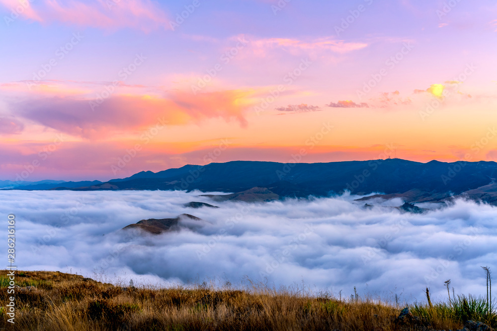 Pink Sunrise over Sea of Clouds and Mountains