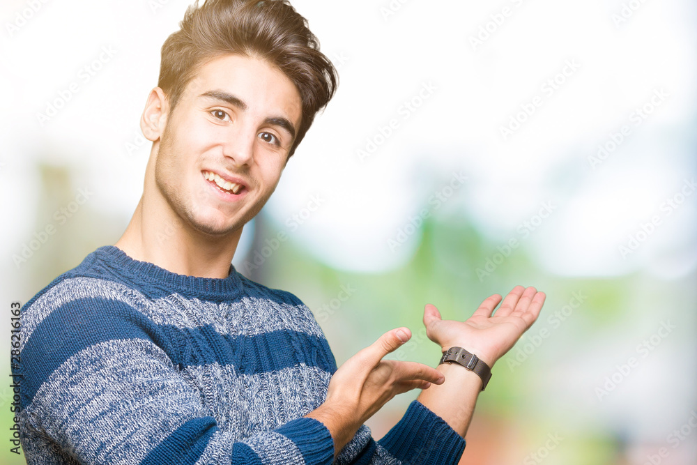 Young handsome man over isolated background Inviting to enter smiling natural with open hand Young handsome man over isolated background Inviting to enter smiling natural with open hand