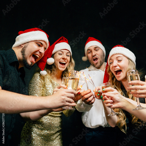 Christmas party. Celebration atmosphere. Friends clinking with champagne glasses on New Year's Eve