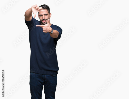 Young handsome man wearing sweater over isolated background smiling making frame with hands and fingers with happy face. Creativity and photography concept.