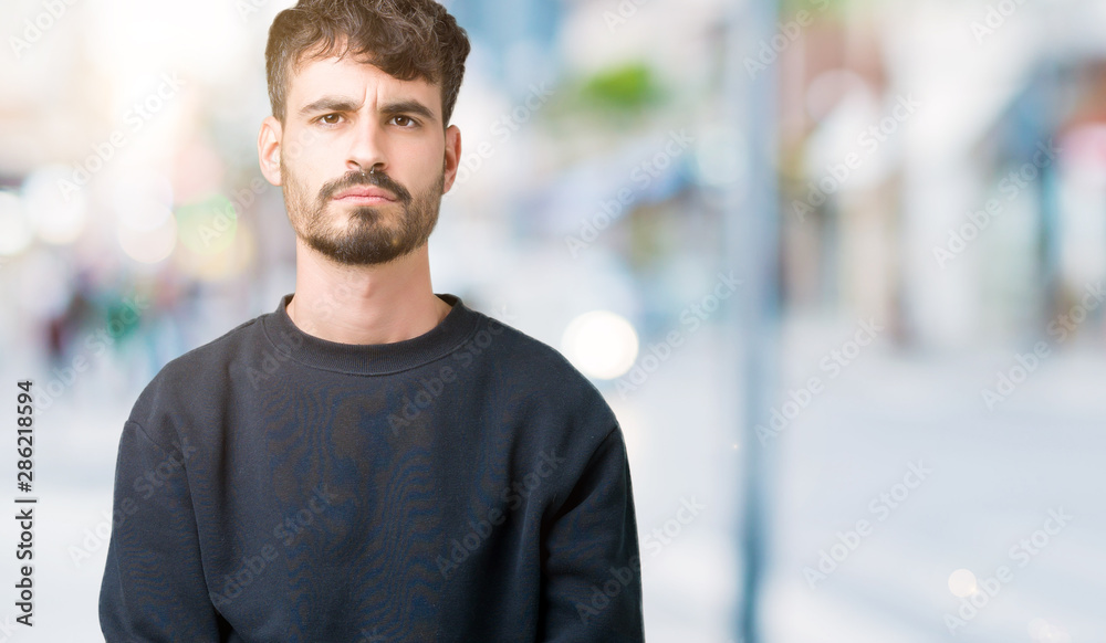 Young handsome man over isolated background skeptic and nervous, frowning upset because of problem. Negative person. Young handsome man over isolated background skeptic and nervous, frowning upset because of problem. Negative person.