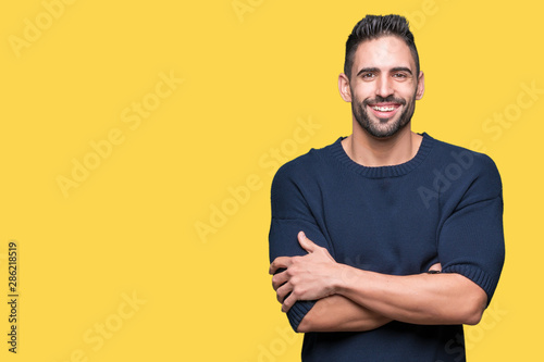 Young handsome man wearing sweater over isolated background happy face smiling with crossed arms looking at the camera. Positive person.