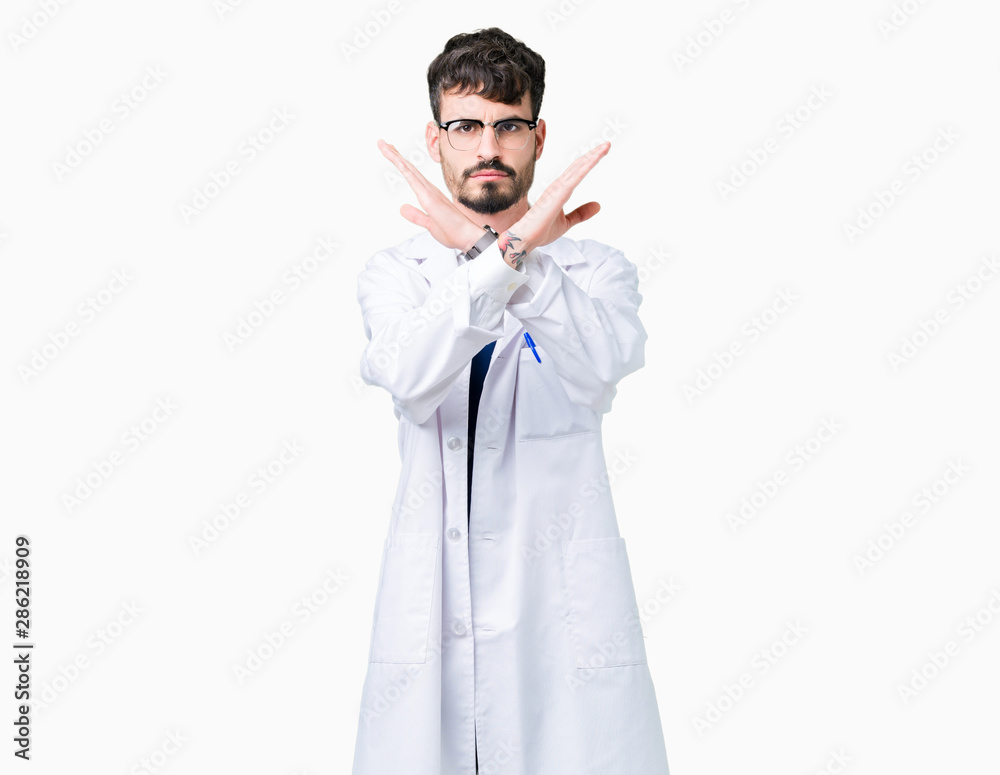 Young professional scientist man wearing white coat over isolated background Rejection expression crossing arms doing negative sign, angry face Young professional scientist man wearing white coat over isolated background Rejection expression crossing arms doing negative sign, angry face