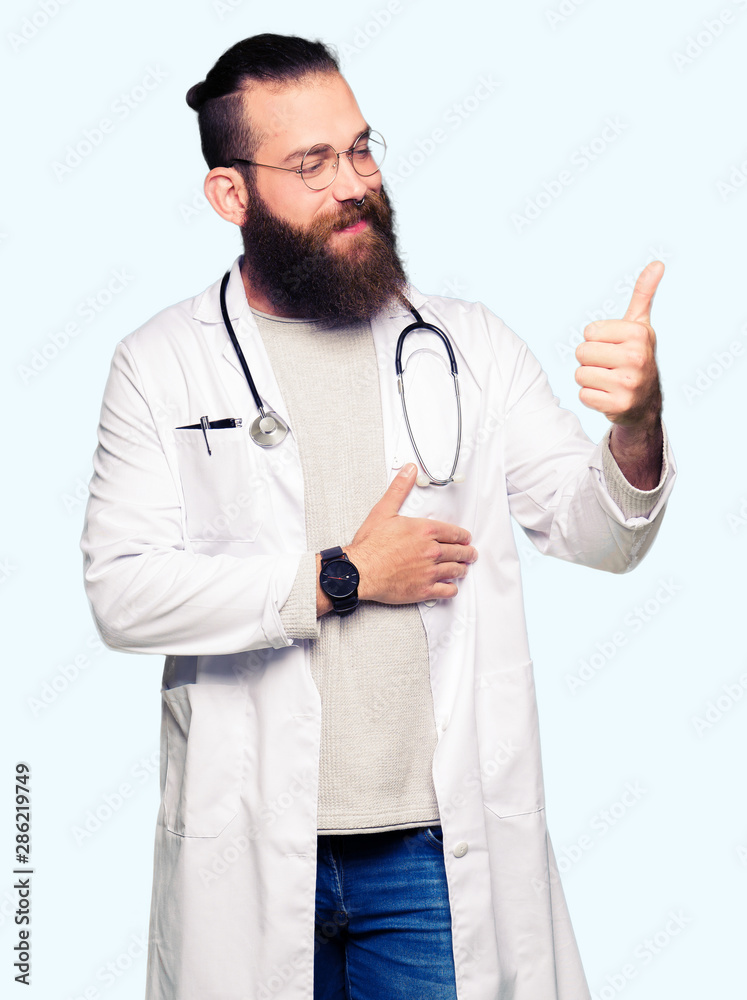 Young blond doctor man with beard wearing medical coat Looking proud, smiling doing thumbs up gesture to the side Young blond doctor man with beard wearing medical coat Looking proud, smiling doing thumbs up gesture to the side