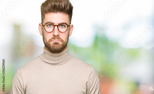 Young handsome business man wearing glasses depressed and worry for distress, crying angry and afraid. Sad expression.