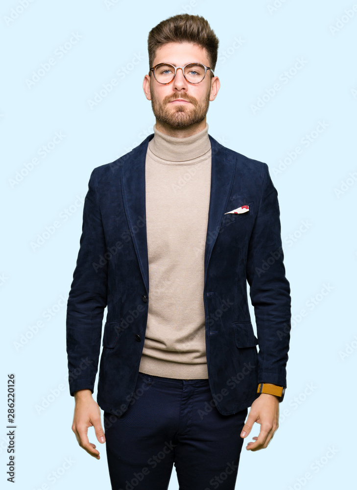 Young handsome business man wearing glasses with serious expression on face. Simple and natural looking at the camera. Young handsome business man wearing glasses with serious expression on face. Simple and natural looking at the camera.