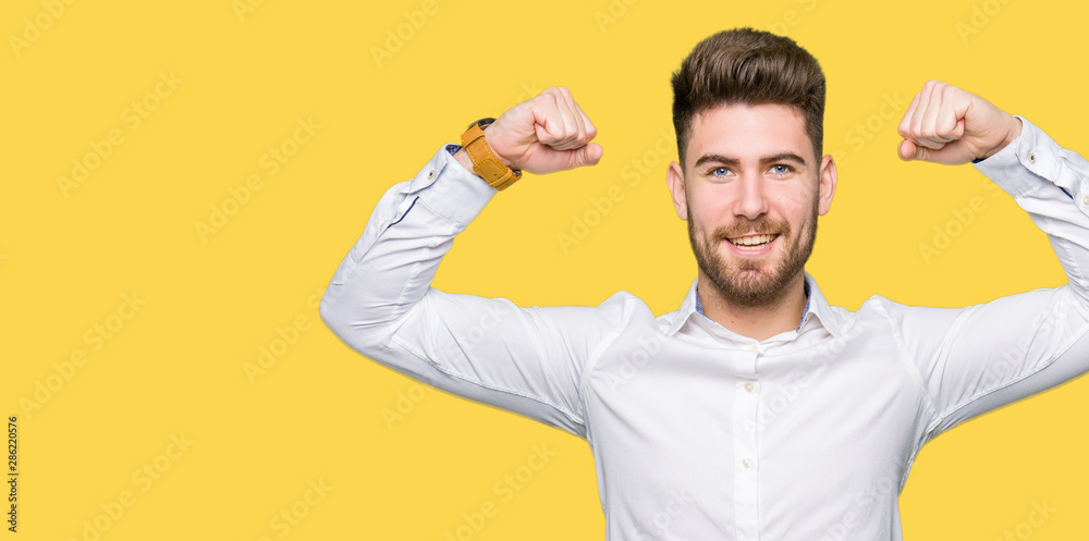 Young handsome business man showing arms muscles smiling proud. Fitness concept. Young handsome business man showing arms muscles smiling proud. Fitness concept.