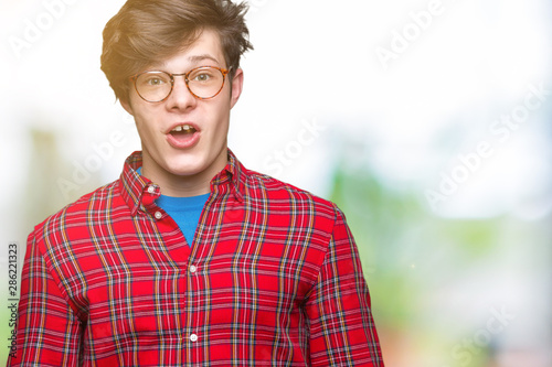 Young handsome man wearing glasses over isolated background afraid and shocked with surprise expression  fear and excited face.