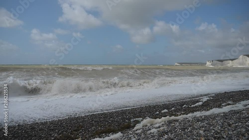 Slow Motion. Powerful waves crashing onto a pebble beach. photo