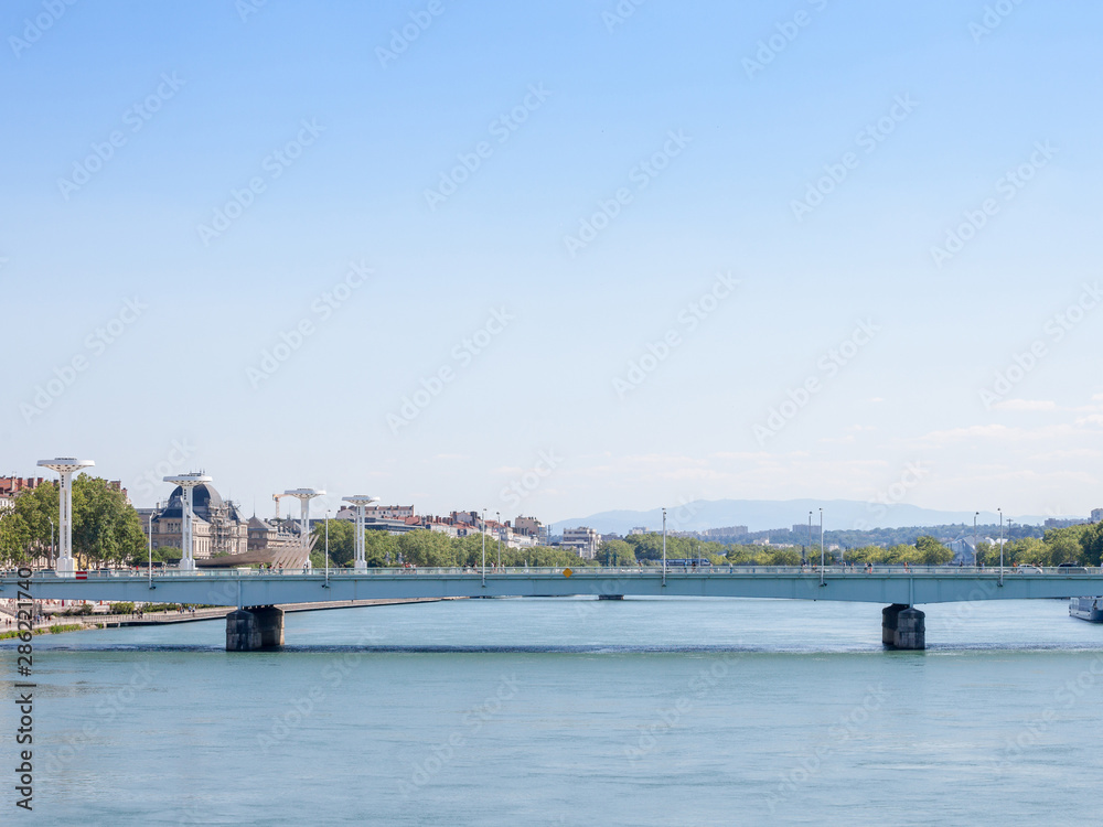 Pont de la Guillotiere bridge in Lyon, France over a panorama of the riverbank of the Rhone river (Quais de Rhone) with older buildings and landmarks in background Pont de la Guillotiere bridge in Lyon, France over a panorama of the riverbank of the Rhone river (Quais de Rhone) with older buildings and landmarks in background