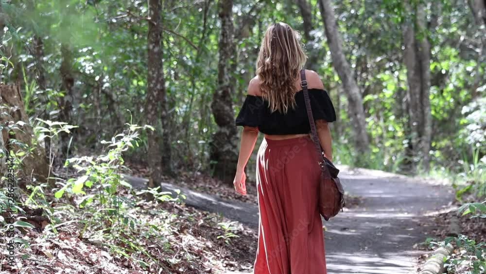 Young woman walking on path in beautiful forest Young woman walking on path in beautiful forest