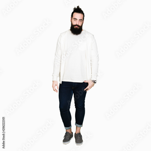 Young man with long hair and beard wearing sporty sweatshirt depressed and worry for distress, crying angry and afraid. Sad expression. © Krakenimages.com