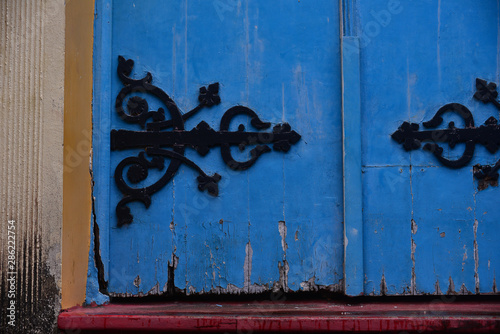 blue door with rustic hinge, ornate hinge, black hinge, colonial, antique door, blue door, medieval hinge, old door, medieval door, iron hinge, colonial architectural detail, vintage style