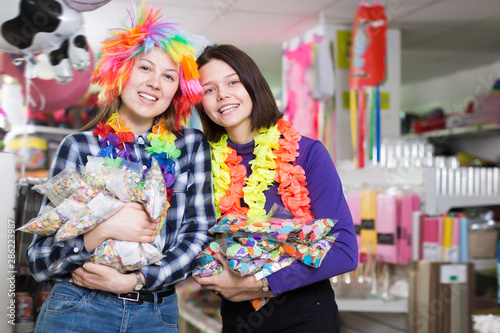 Cheerful female friends with bags of confetti