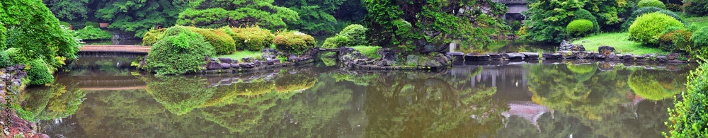 Traditional Japanese gardens in public parks in Tokyo, Japan. Views of stone lanterns, lakes, ponds, bonsai and wildlife walking around paths and trails. Asia. 