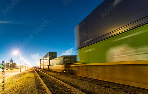 Night train locomotive in motion on railroad at night.